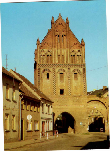 Historisches Stadttor mit gotischer Architektur in einer ruhigen Straße.