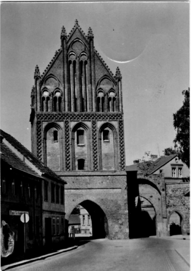 Historisches Gebäude mit gotischer Architektur und einem Bogen über einer Straße.